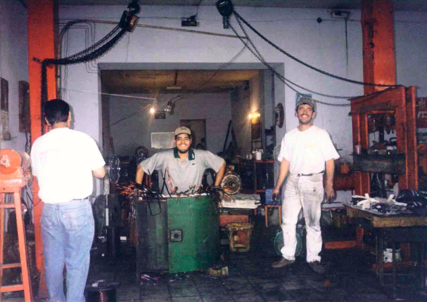 Equipo técnico TEMISA trabajando en taller histórico con prensa hidráulica — formación profesional desde los inicios