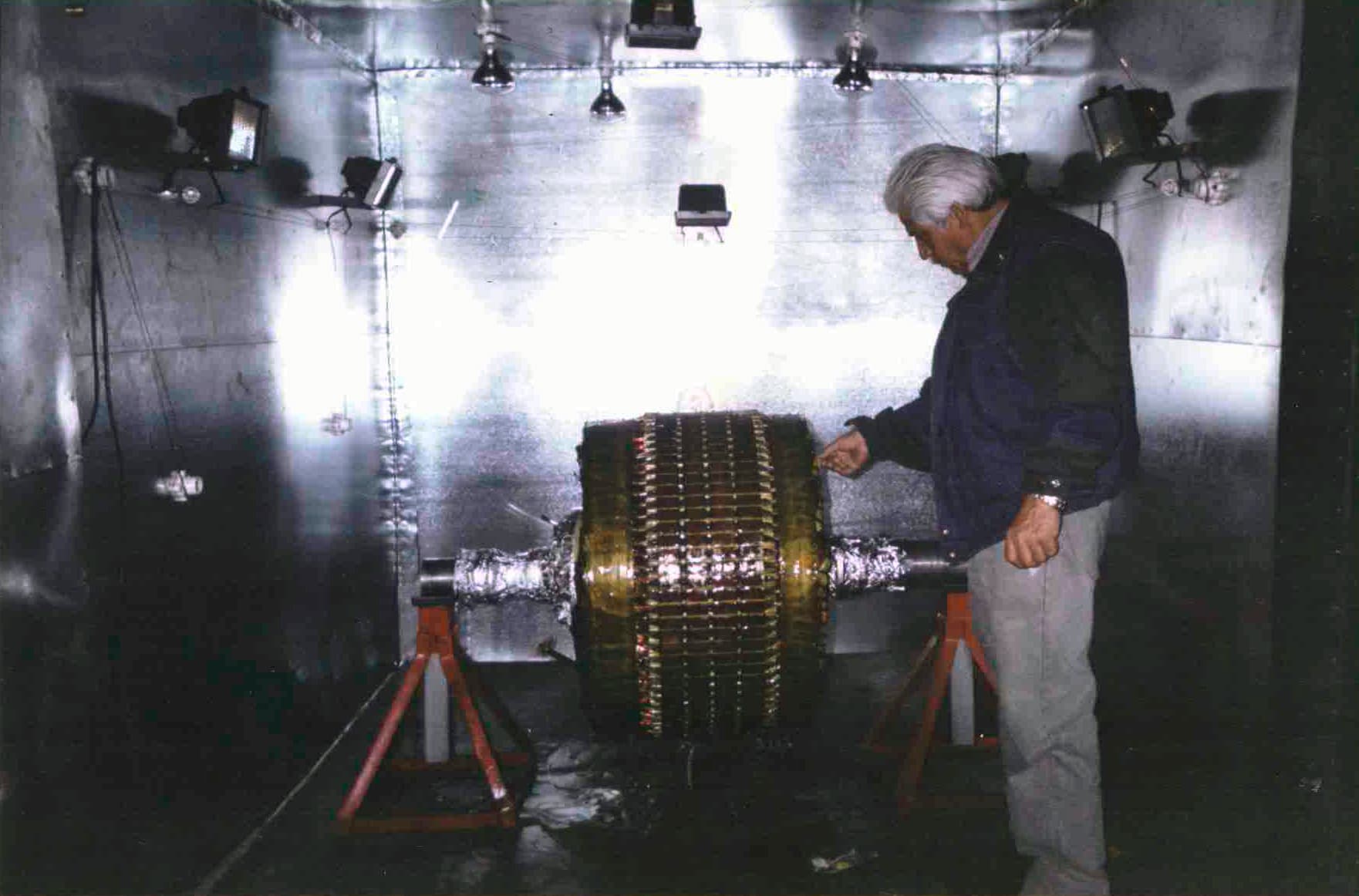 Don Jesús Sainz Bello inspeccionando rotor de generador en cámara especial de iluminación — continuidad de la tradición técnica familiar