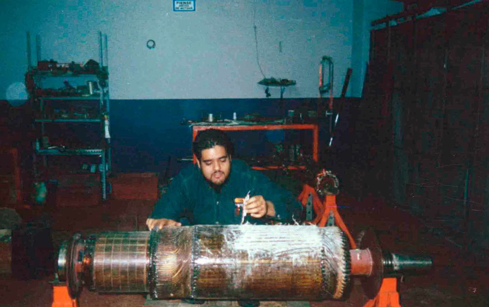 Técnico TEMISA midiendo motor industrial con instrumento eléctrico — prácticas técnicas del taller original