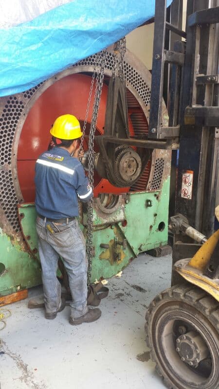 Técnico TEMISA con casco amarillo manipulando estator de generador con montacargas — capacidad de manejo de equipos pesados